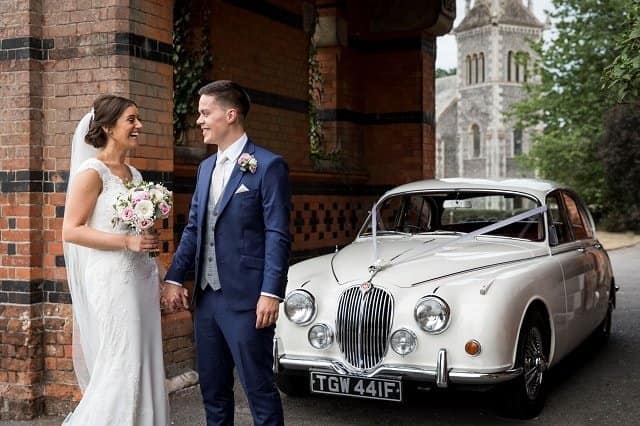 The Bride and Groom at the Elvetham Hotel standing by our classic Jaguar Mk2
